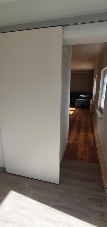 a view of a living room with white walls and wood floors at FeWo Warnemüde in Warnemünde