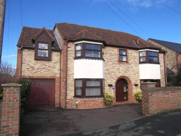 a brick house with a garage and a driveway at Byerley House in Newmarket
