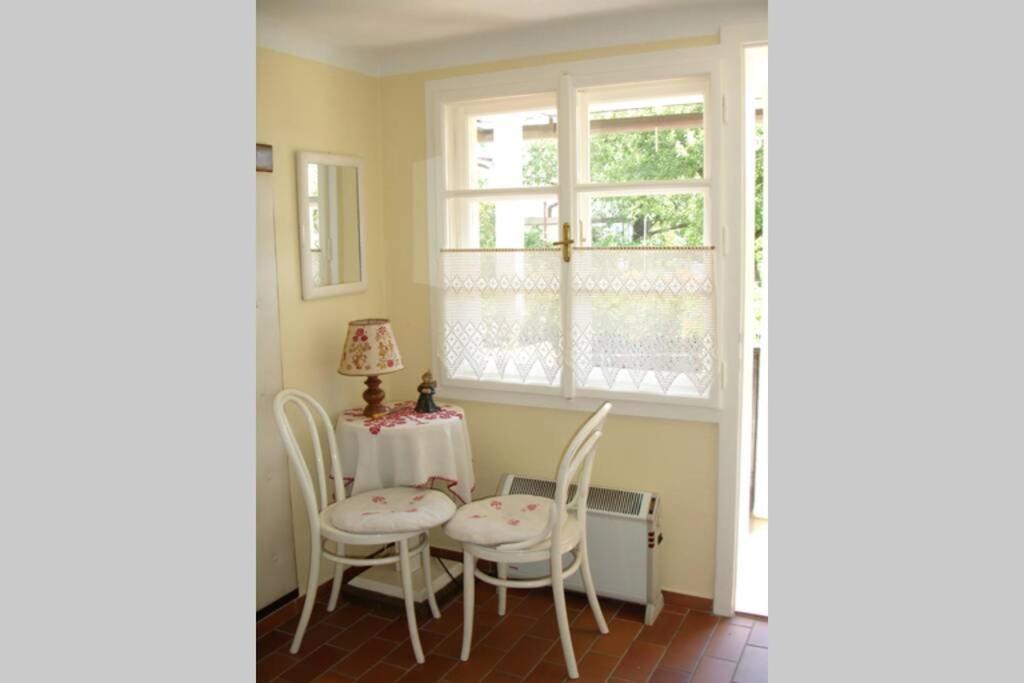 una sala da pranzo con tavolo, sedie e una finestra di Villa Lindwurm a Klagenfurt
