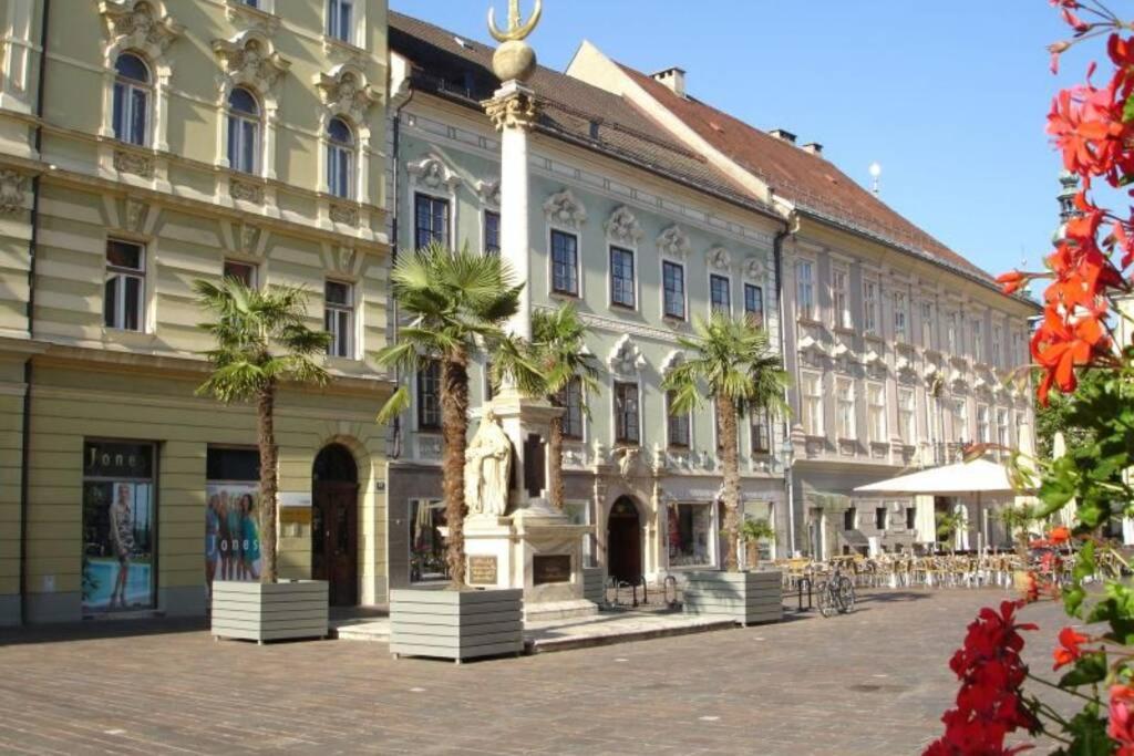 un grande edificio con palme di fronte di Villa Lindwurm a Klagenfurt