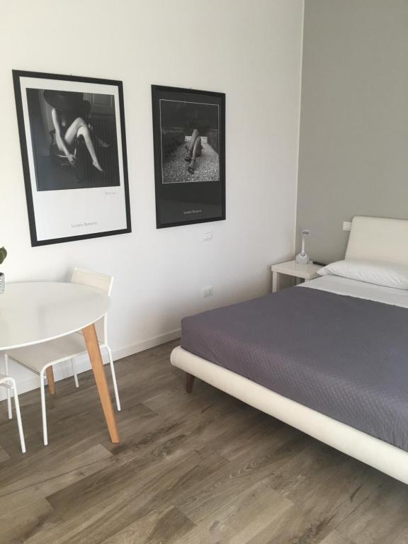 ヴァレッジョ・スル・ミンチョにあるRelax & Emozioni Roomsのベッドルーム1室(ベッド1台、白いテーブル付)
