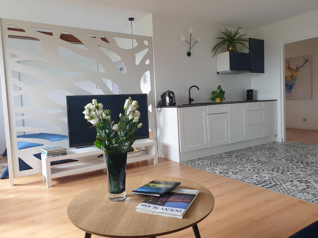 a living room with a vase of flowers on a table at Apartament Panorama in Jeżów Sudecki