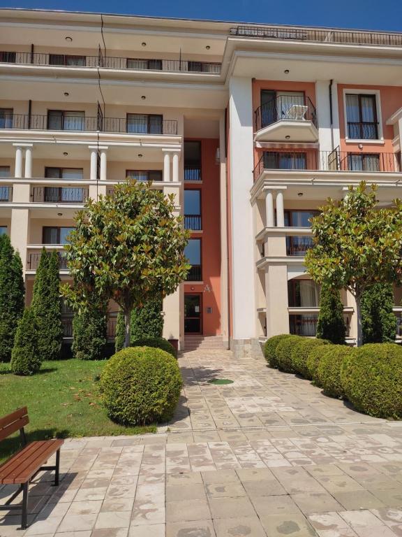 a building with trees and a bench in front of it at Prestige Fort Beach Private Apartment-Studio 46 in Sveti Vlas