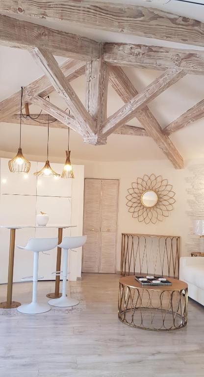 - un salon avec des plafonds en bois, une table et des chaises dans l'établissement Studio villa château Currault, à Mougins