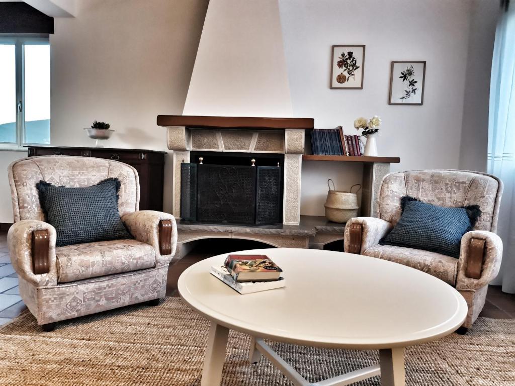 sala de estar con 2 sillas y mesa de centro en Casa Courcelles - Viveiro, en Viveiro