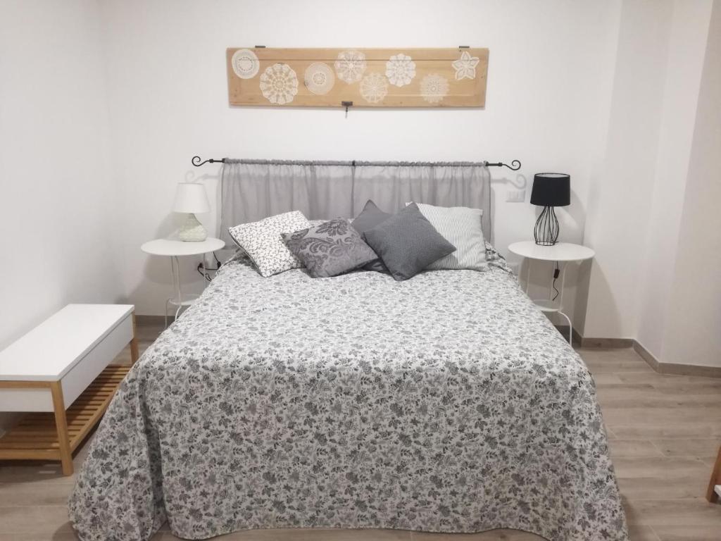 una camera da letto con un letto con una coperta e cuscini di B&B Casa Lilli a Foligno