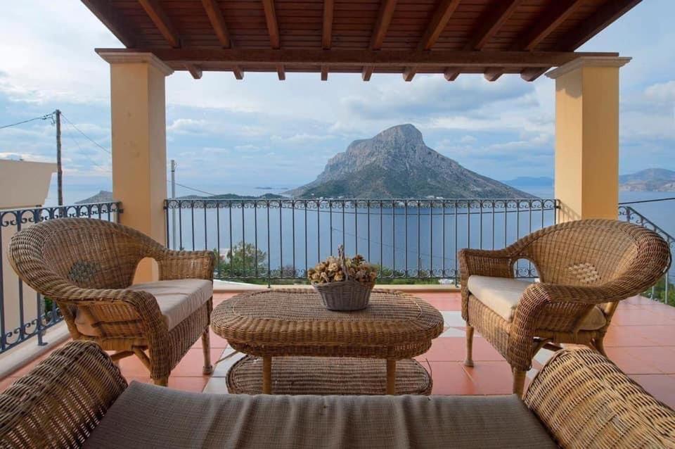patio ze stołem i krzesłami oraz góry w obiekcie VILLA NEXT TO THE SEA!! w mieście Kalimnos