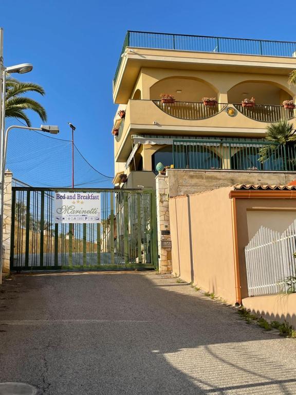 un bâtiment avec un portail et une clôture dans l'établissement B&B Villa Marinetti, à Gela