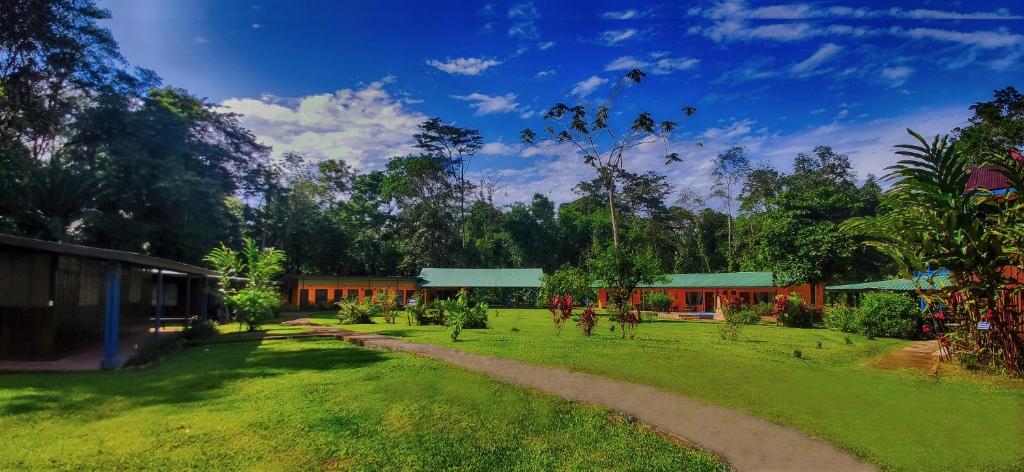 a house in the middle of a field with a dirt road at Gran Gavilán del Sarapiquí Lodge in Sarapiquí