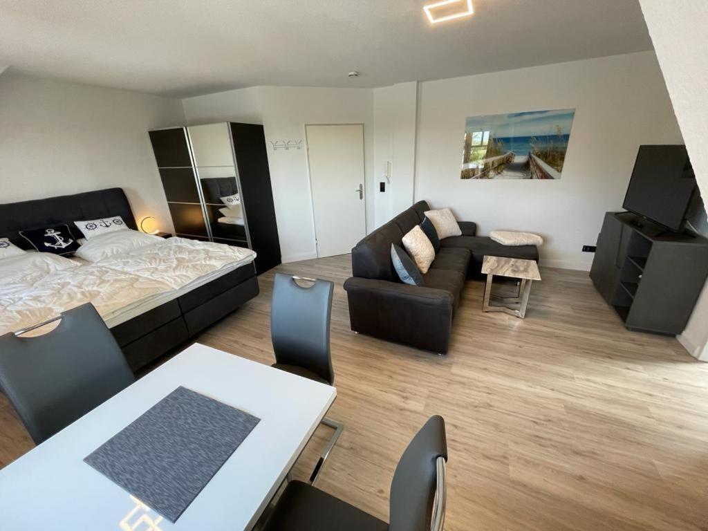 a bedroom with a bed and a living room at Studio-Apartment Ankerplatz im Ferien-Resort Rügen in Neddesitz