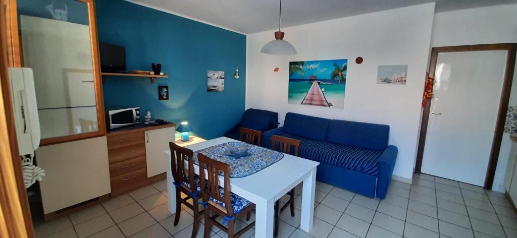 a living room with a table and a blue couch at Appartamento Sabrina in San Vito lo Capo