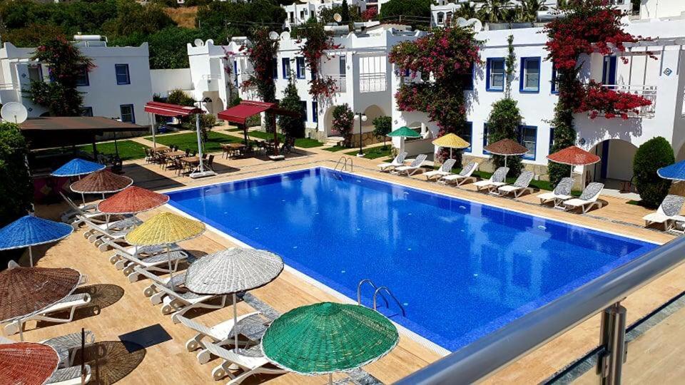 una piscina al aire libre con sillas y sombrillas en Paradise Apart Hotel, en Gümbet