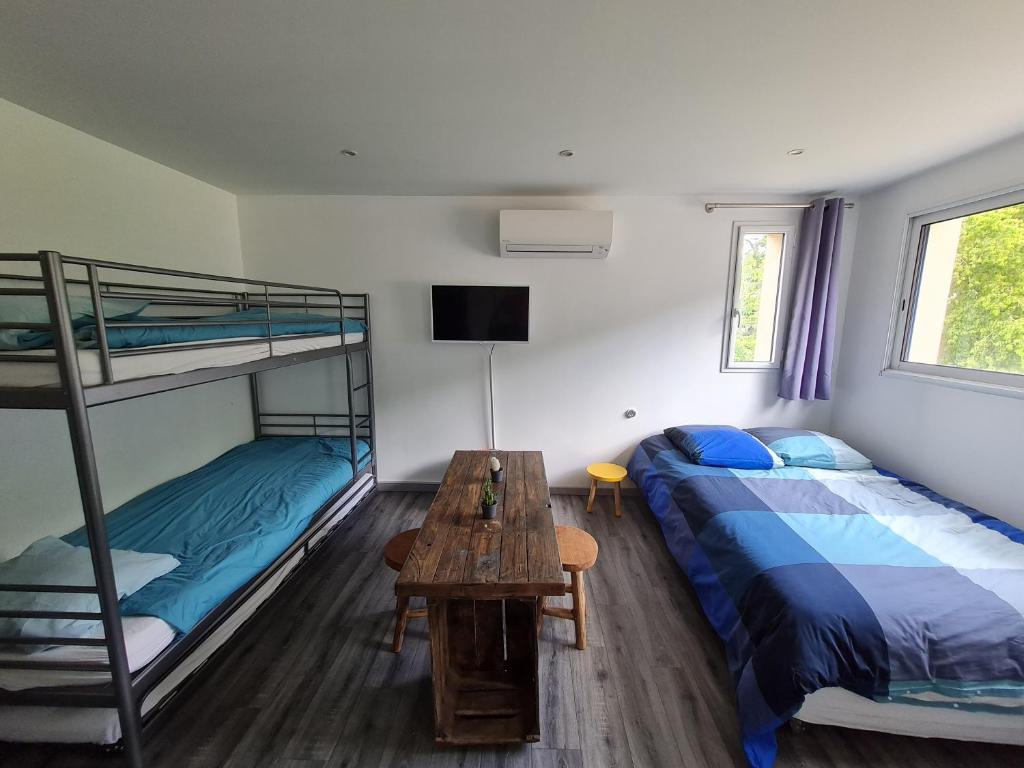 a bedroom with two bunk beds and a table at Studio indépendant climatisé in Veigné