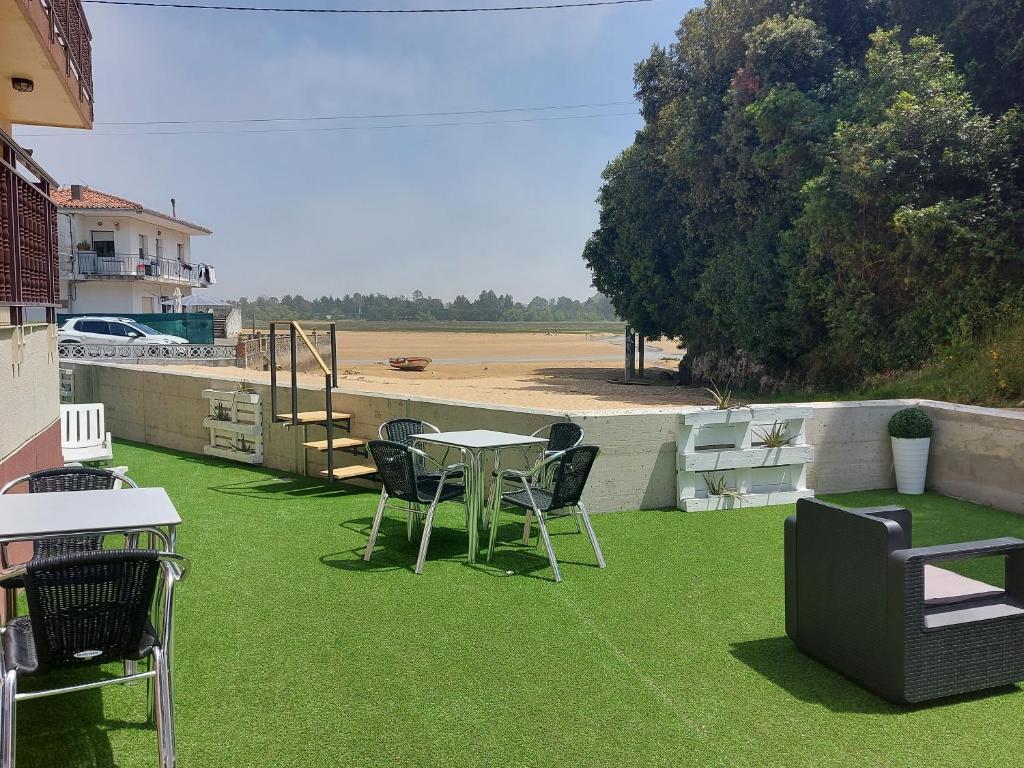 a patio with a table and chairs on the grass at Hotel Villa in Isla