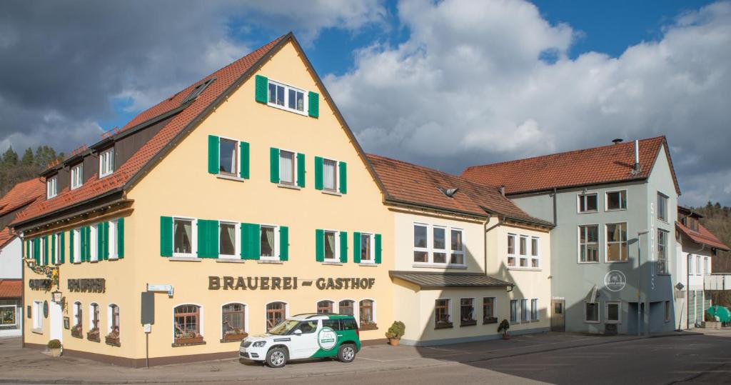 un bâtiment avec une voiture garée devant lui dans l'établissement Brauereigasthof zum Lamm, à Untergröningen