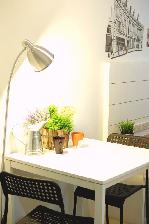 A small white table set up as a bright two-seat work or dining nook.