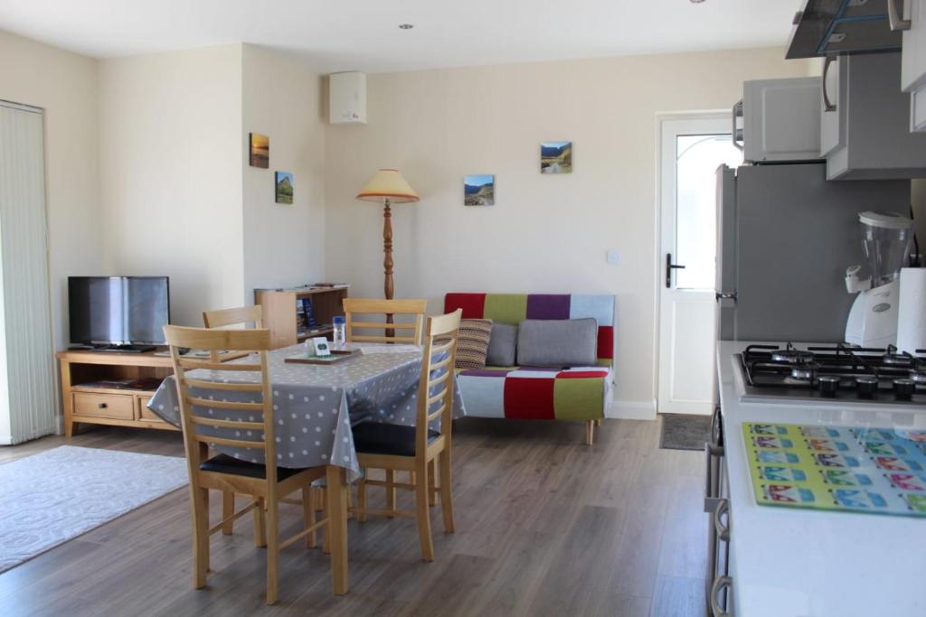 a kitchen and living room with a table and chairs at Ben Haven Self Catering Accommodation in Ballaghnatrillick