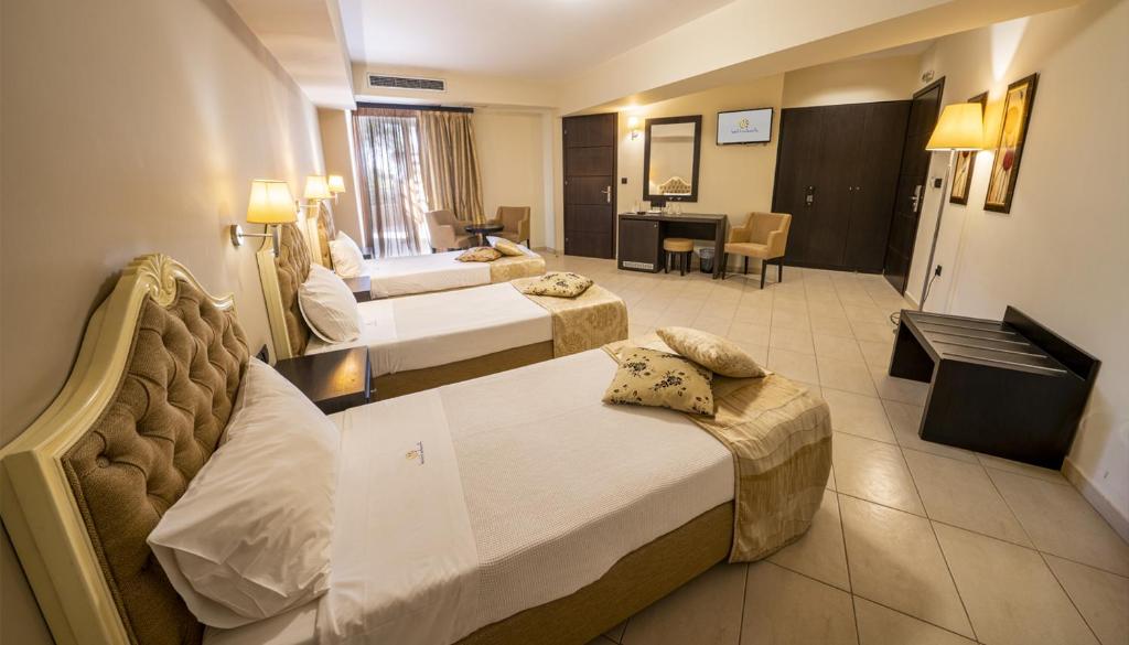 Habitación de hotel con 2 camas y escritorio en Amalias Hotel en Kourouta