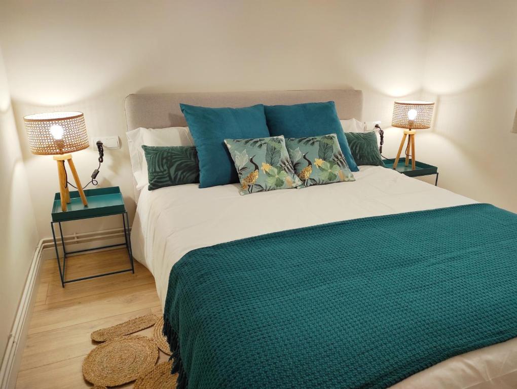 una camera da letto con un grande letto verde con due lampade di FLOR DE LIS a Sant Hilari Sacalm