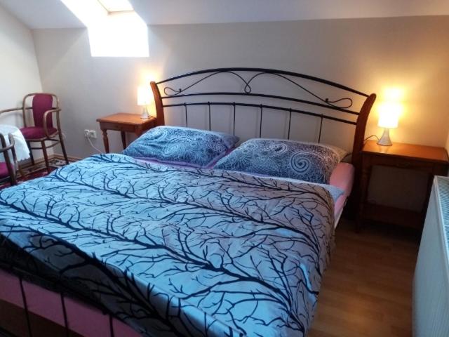 a bedroom with a large bed with blue sheets and pillows at Apartmán Podskalská Blatná in Blatná