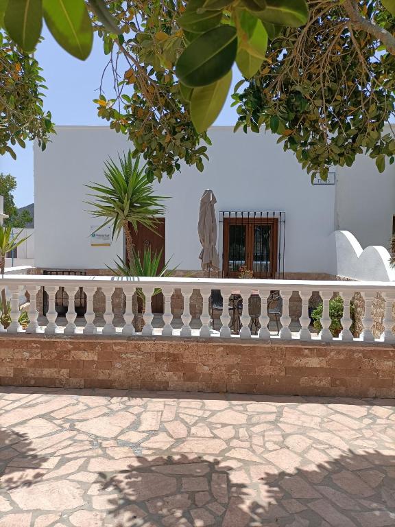 una cerca frente a un edificio blanco con una estatua en Casa Redondo, en Rodalquilar