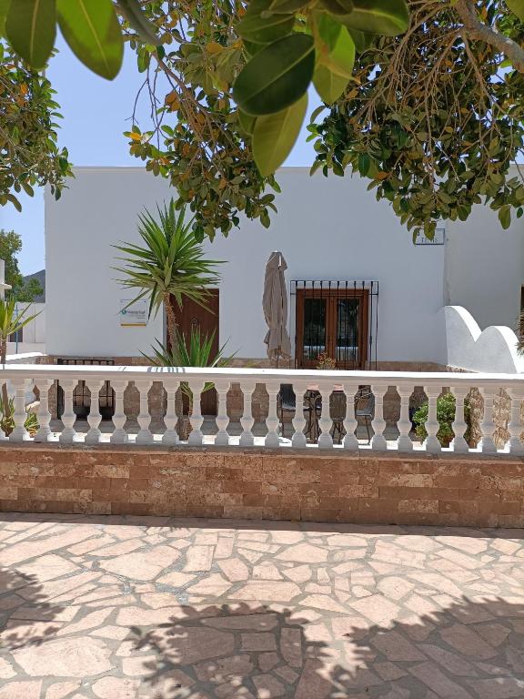 a fence in front of a white building with a statue at Casa Redondo in Rodalquilar