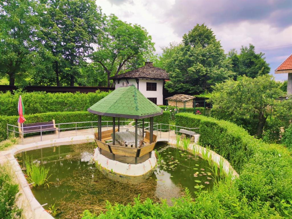 un pequeño barco en un estanque en un jardín en Дургунската къща -Durgunskata kashta, en Stolat