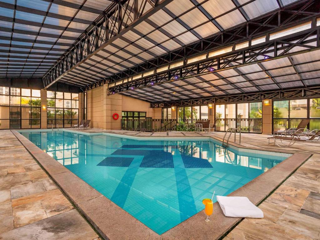 a large swimming pool in a large building at Mercure Sao Paulo Pinheiros in São Paulo
