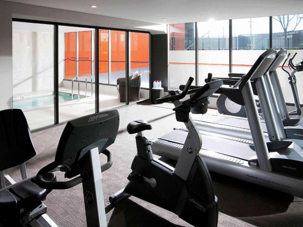 a gym with treadmills and elliptical machines at Novotel Newcastle Beach in Newcastle