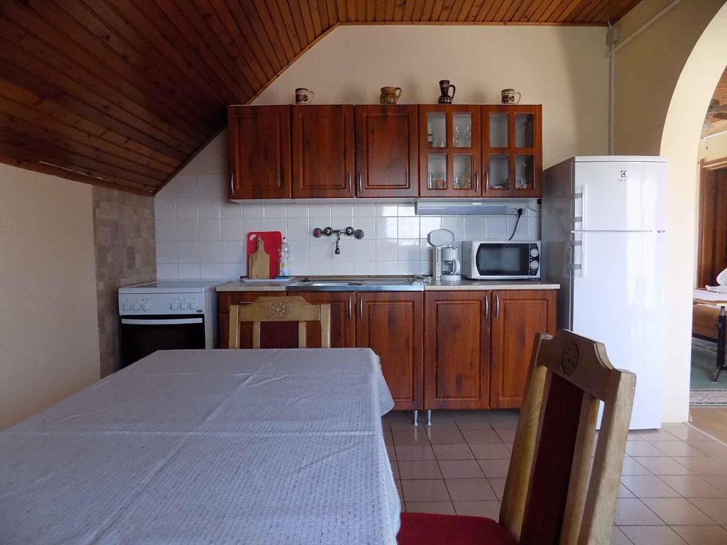 ギェネシュディアーシュにあるThree-Bedroom Apartment in Gyenesdias Iのキッチン(テーブル、白い冷蔵庫付)