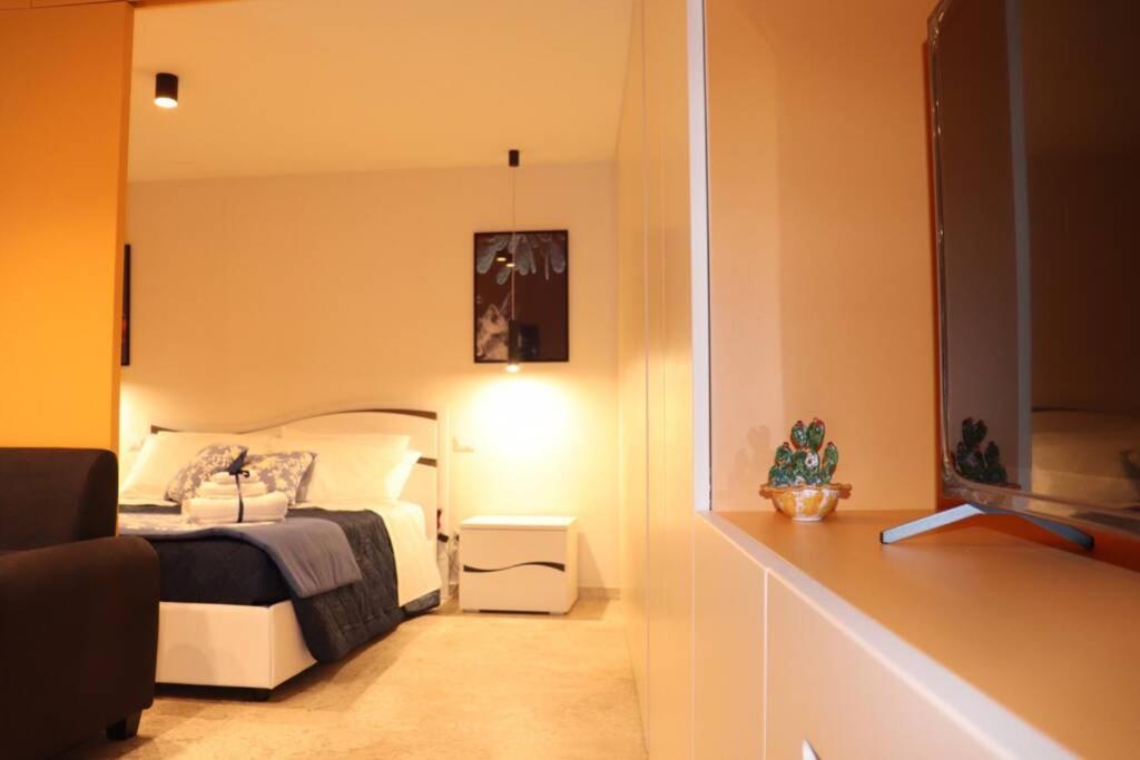 a bedroom with a bed and a mirror at La casetta di Nonna Paola in Palazzolo Acreide