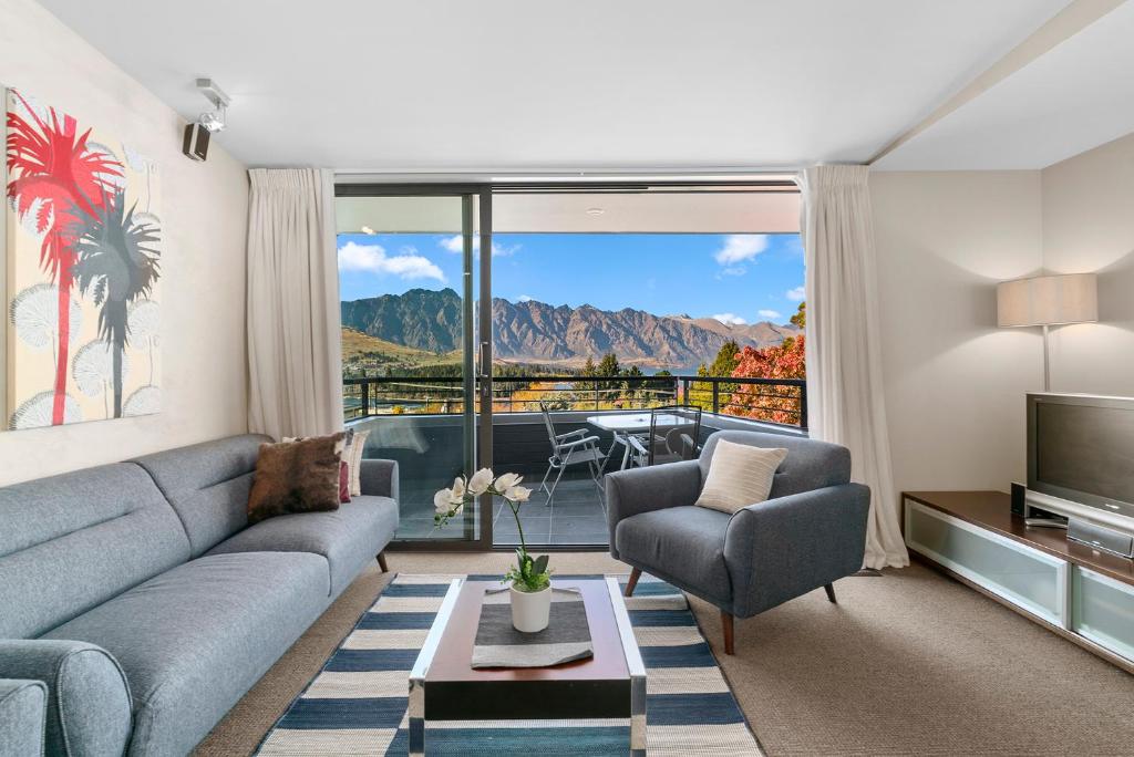 a living room with a couch and a television at Lomond Retreat - Near CBD Executive Apartment in Queenstown