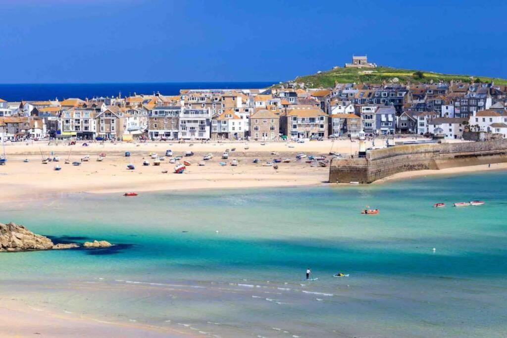 a view of a beach with people in the water at Luna Beach - Luxury Carbis Bay Apartment + Parking in Carbis Bay