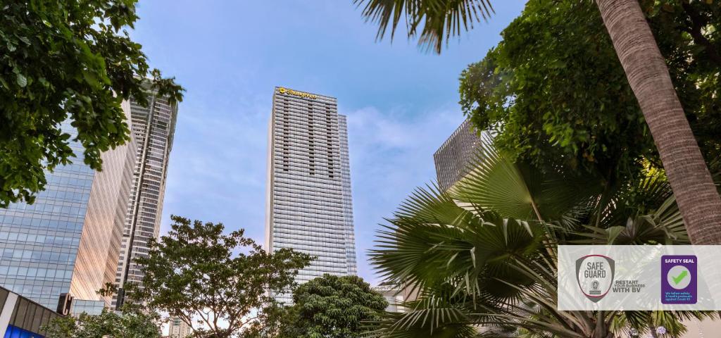 two tall buildings in a city with palm trees at Shangri-La The Fort, Manila in Manila