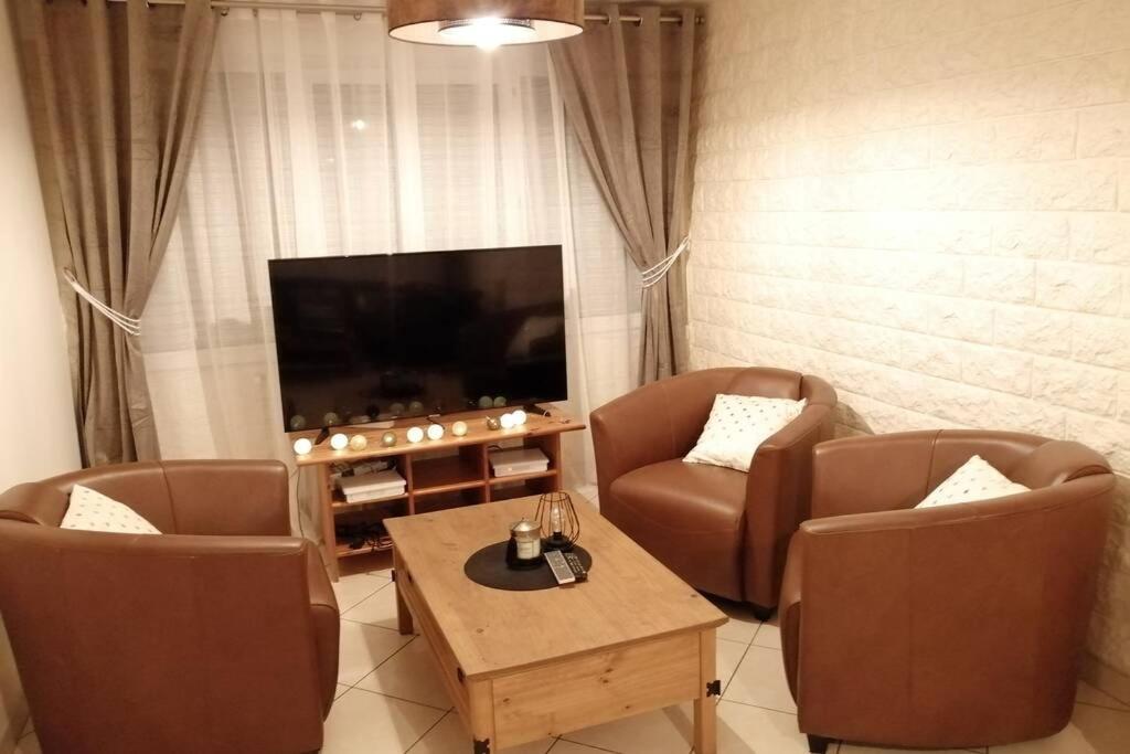un soggiorno con 2 sedie e una TV a schermo piatto di Médina maison 4 chambres 100m2 a Beuvrages