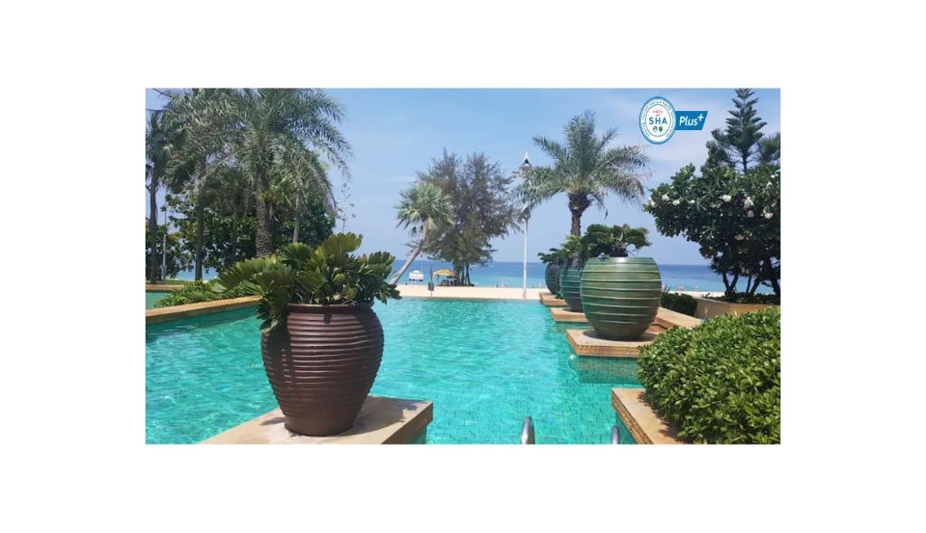 uma piscina com três grandes potes com plantas em Karon Sea View Beach Apartment em Praia de Karon