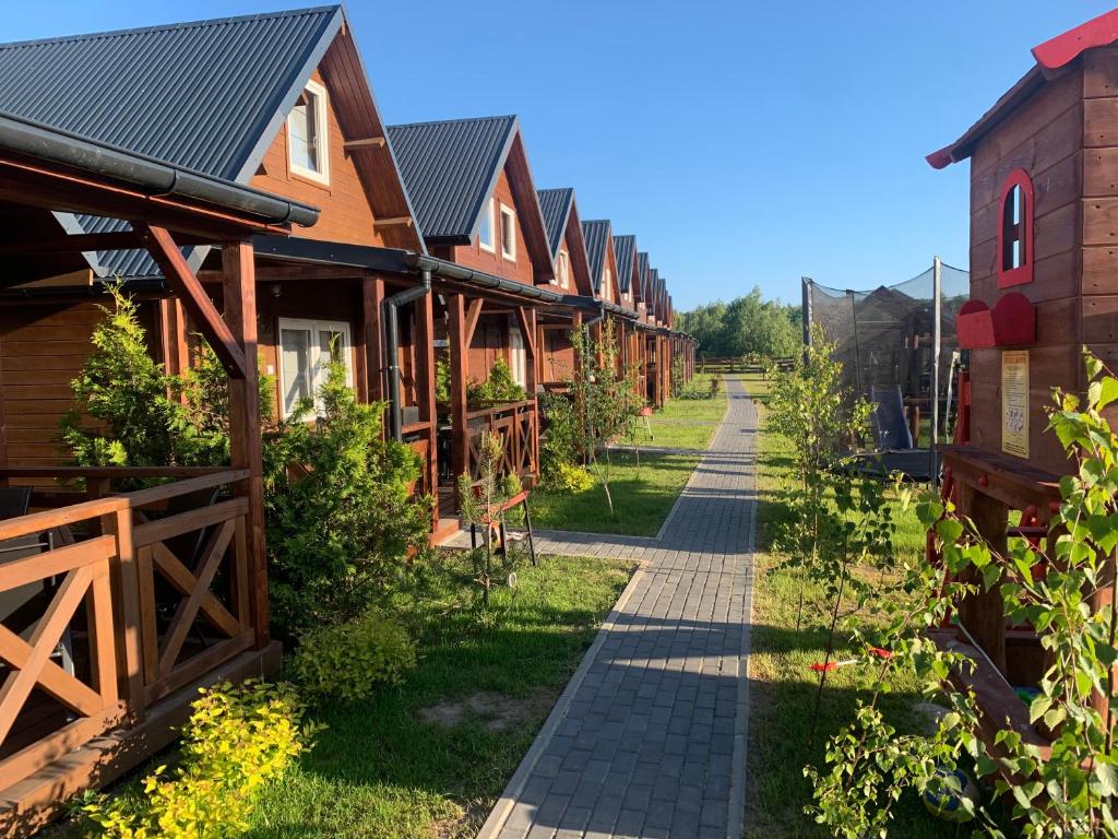 eine Reihe von Cottages mit einem Weg in der Unterkunft Pod Dębami Wicie- domki drewniane nad morzem in Vitte