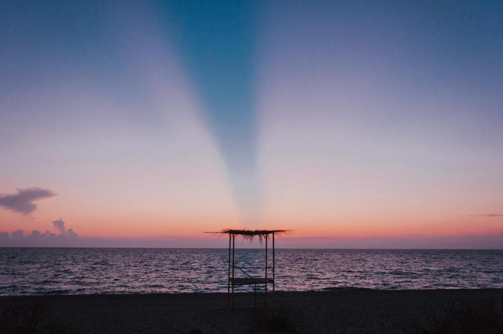a umbrella on the beach at sunset at Casa Costa Suites in Kanali