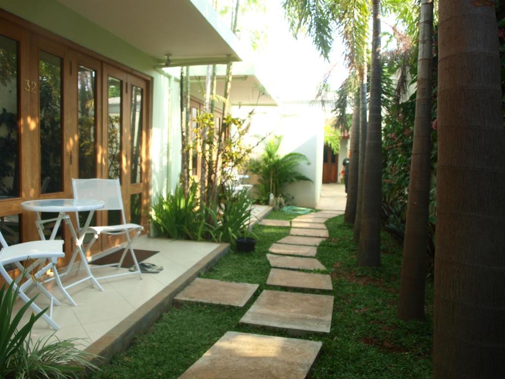 a garden with a table and chairs on the grass at The Gecho Inn Town in Jepara