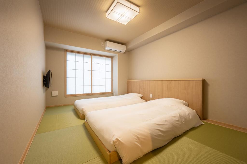 Postel nebo postele na pokoji v ubytování Fuji Hotel Kyoto Gojo