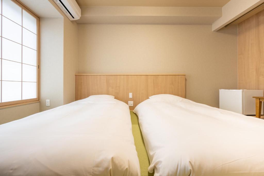 Postel nebo postele na pokoji v ubytování Fuji Hotel Kyoto Gojo