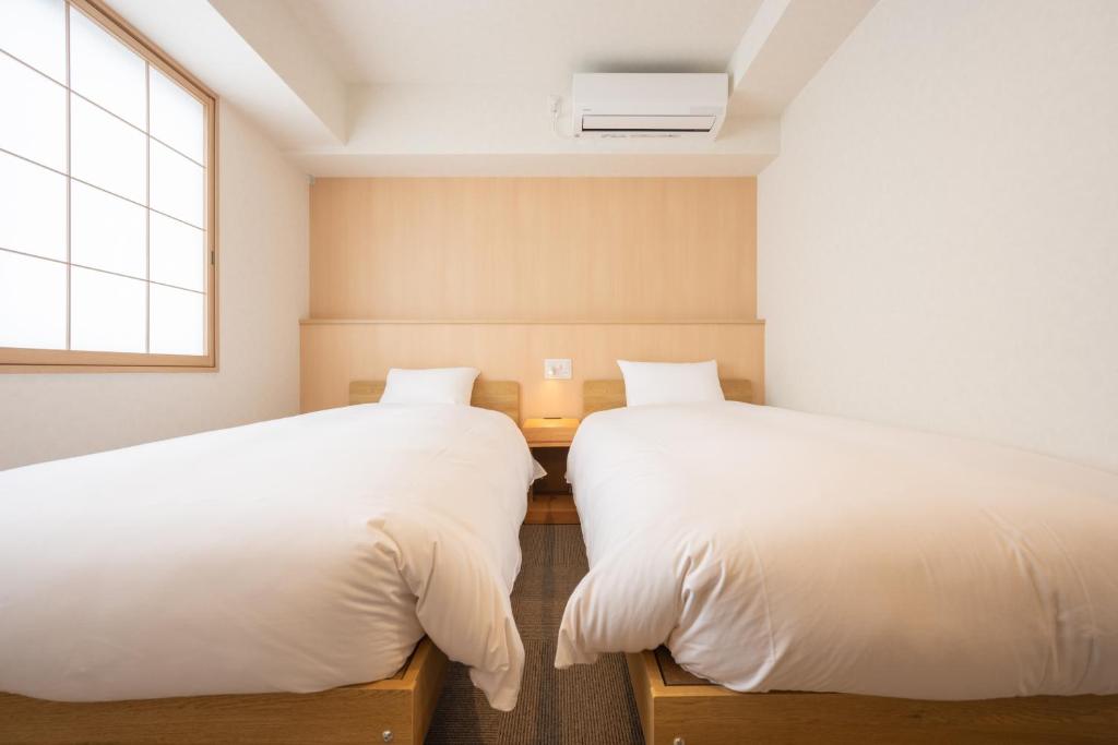 Postel nebo postele na pokoji v ubytování Fuji Hotel Kyoto Gojo