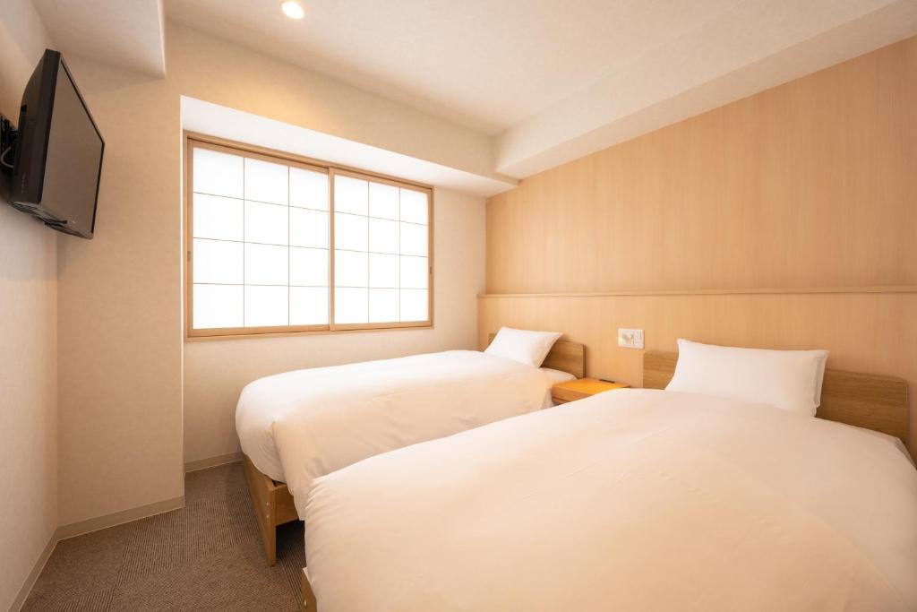 Postel nebo postele na pokoji v ubytování Fuji Hotel Kyoto Gojo
