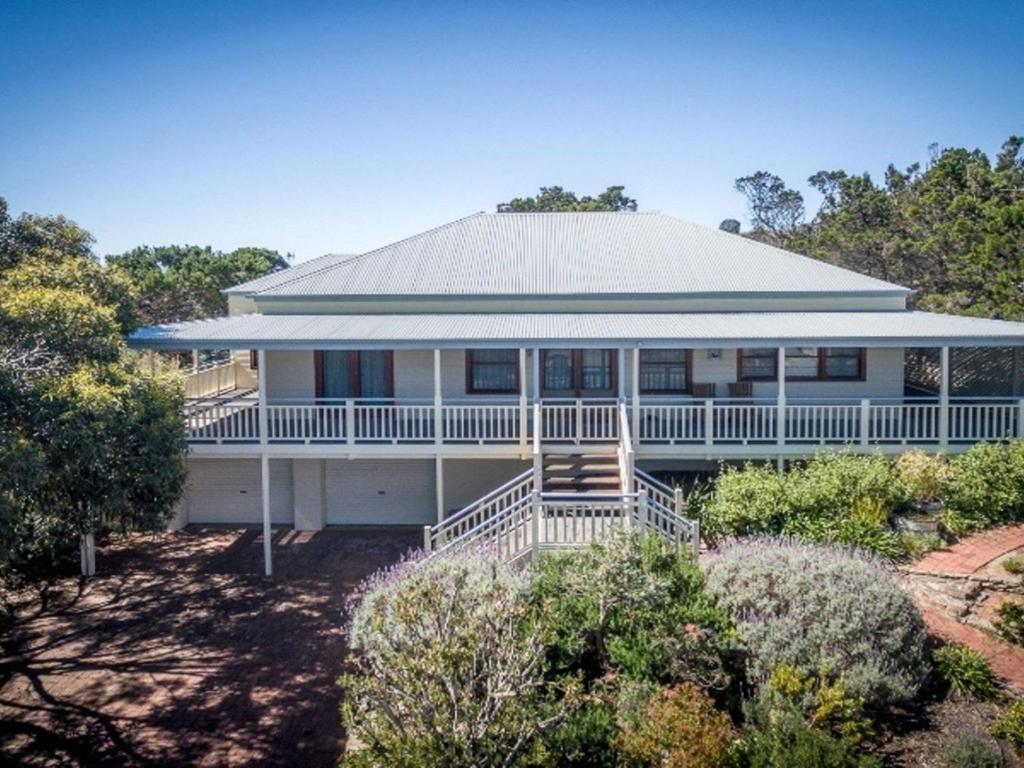 a large white house with a porch at 3 Banksia Court in Normanville