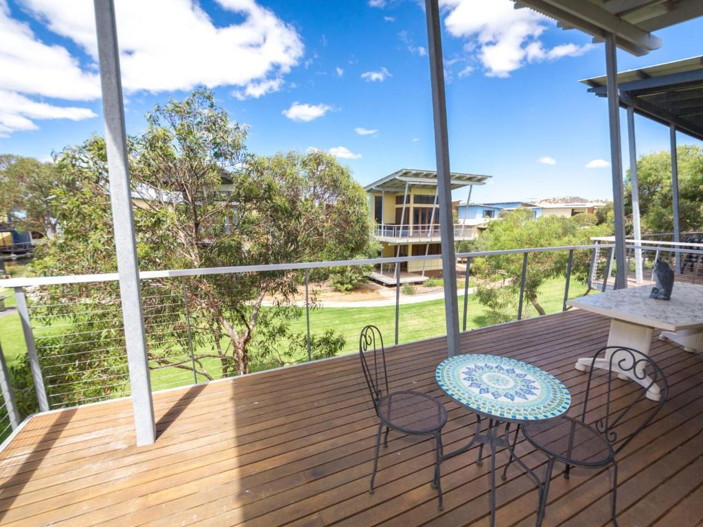 a porch with a table and chairs on a deck at South Shores Villa 50 in Normanville