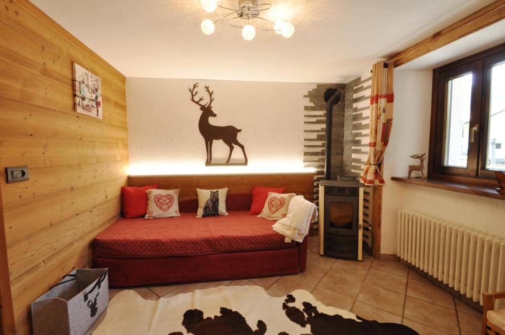 a room with a bed with a deer on the wall at Bilocale montano in La Thuile