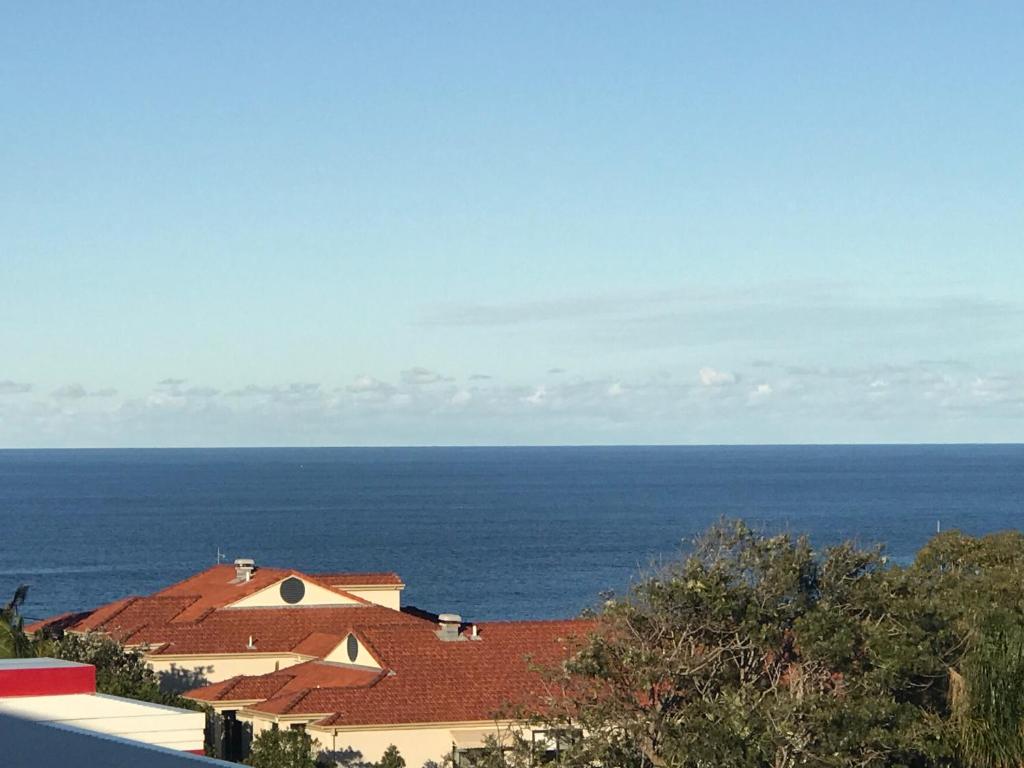 a view of a house with the ocean in the background at Ocean View from Balcony - Xmas by the Sea in Port Macquarie