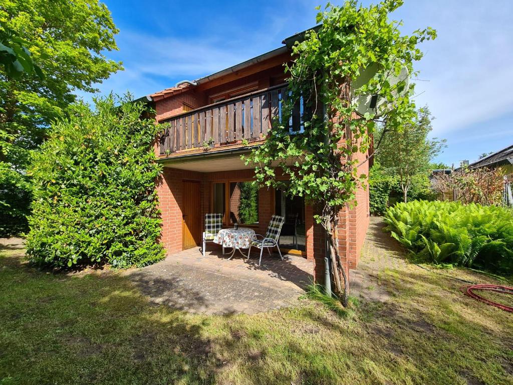 a house with a table and chairs in a yard at Schickebude-Steinhude-1-400m-zum-naechsten-oeffentlichen-Wasserzugang-5-Minuten-zur-Badeinsel-ruhige-Lage-mit-schoenem-Aussenbereich in Steinhude