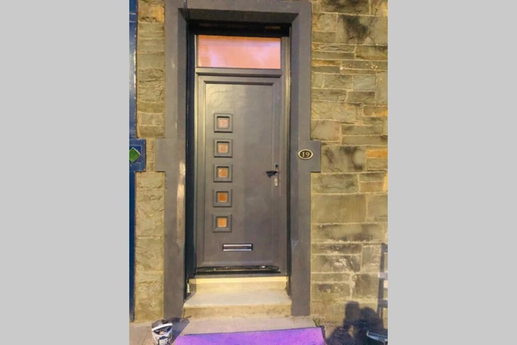 una puerta en un edificio de piedra con una alfombra púrpura en The Coop en Castle Douglas