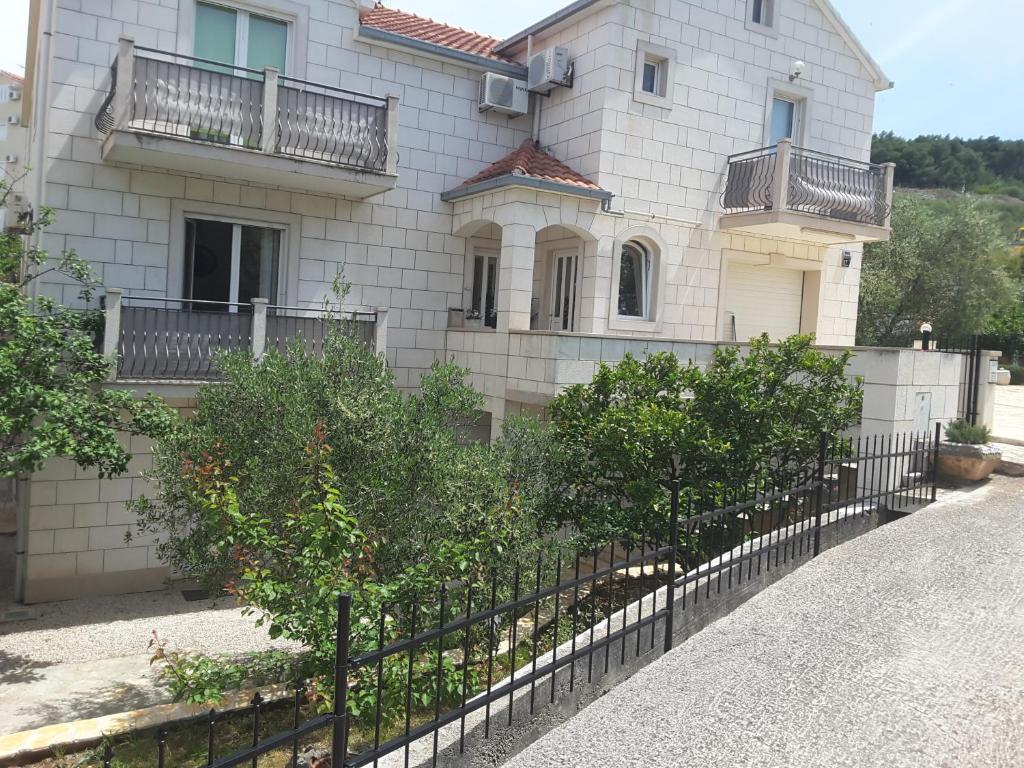 a house with a fence in front of it at Apartments Nives in Supetar